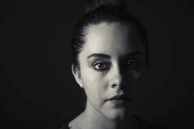 Close-up of a woman's face with a tear rolling down her cheek.
