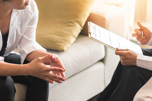 Psychiatrist consulting woman patient for mental health on couch