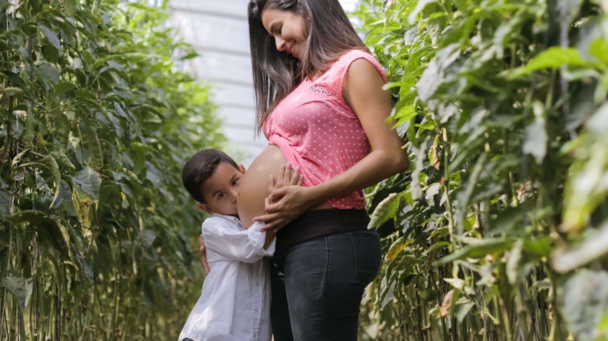 Boy hugging pregnant woman's belly